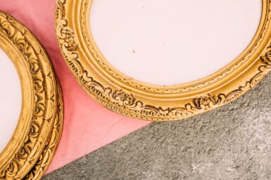 a close up of two gold framed mirrors